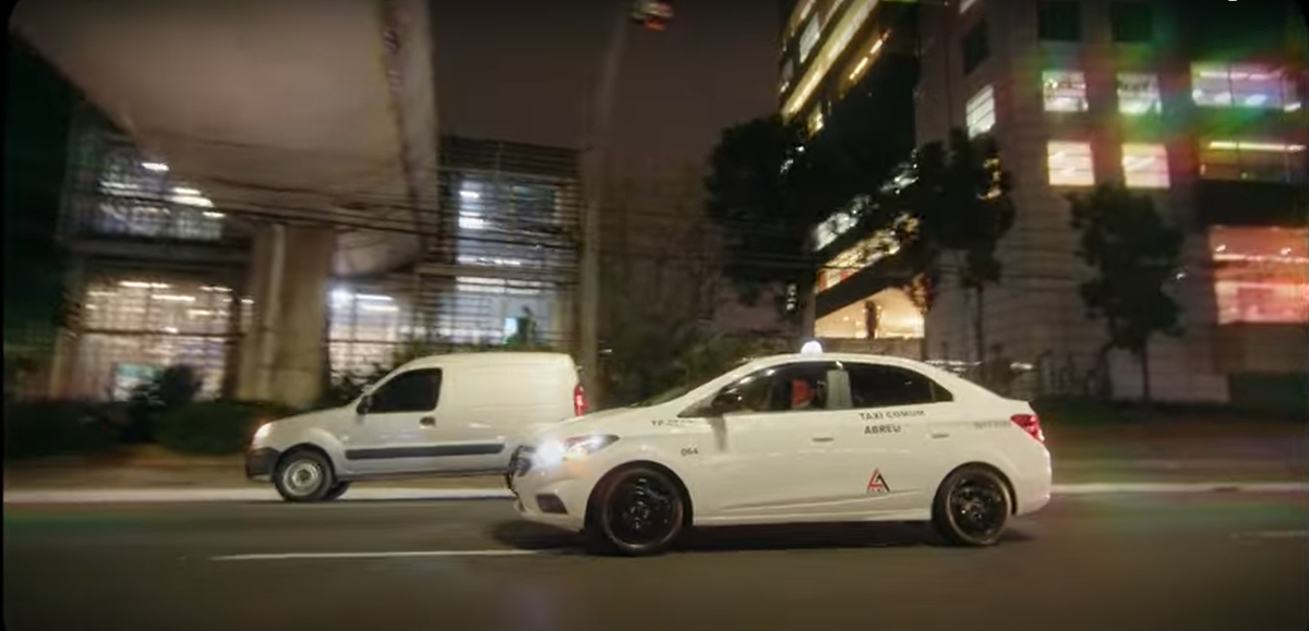 Taxi branco em movimento em avenida